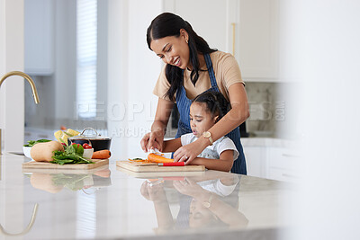 Buy stock photo Cooking food, mother and child cutting vegetables helping prepare healthy vegan diet dinner in the kitchen at home learning and having fun. Happy woman and girl kid family teaching culinary skills
