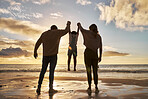 Family, beach and silhouette with parents and a girl in the air during sunset by the ocean or sea on vacation. Love, water and nature with a mother, father and daughter bonding on a coast holiday