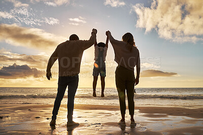 Buy stock photo Family, beach and silhouette with parents and a girl in the air during sunset by the ocean or sea on vacation. Love, water and nature with a mother, father and daughter bonding on a coast holiday