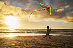 Kite, child and beach fun of a kid running by the ocean waves at a summer sunset. Boy run on the sea sand in nature enjoying vacation, youth travel and water outdoor happy, relax and content