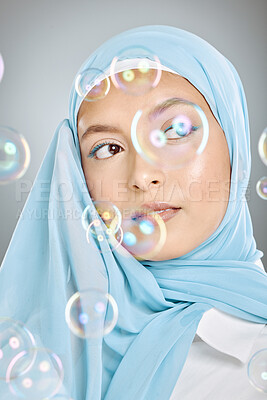 Buy stock photo Skincare, bubbles and Muslim model with beauty, idea and thinking against a grey studio background. Young, Islamic and cosmetic woman with a hijab, makeup and vision for dermatology with bubble