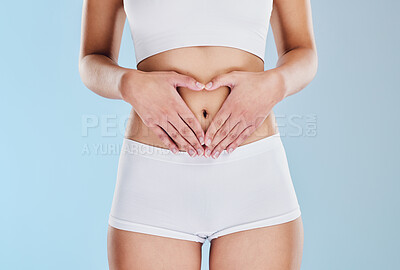 Buy stock photo Healthy stomach, heart and woman hands, wellness and gut health, body contouring and diet on studio blue background. Fitness model belly love, digestion and skincare, laser liposuction and abdomen 
