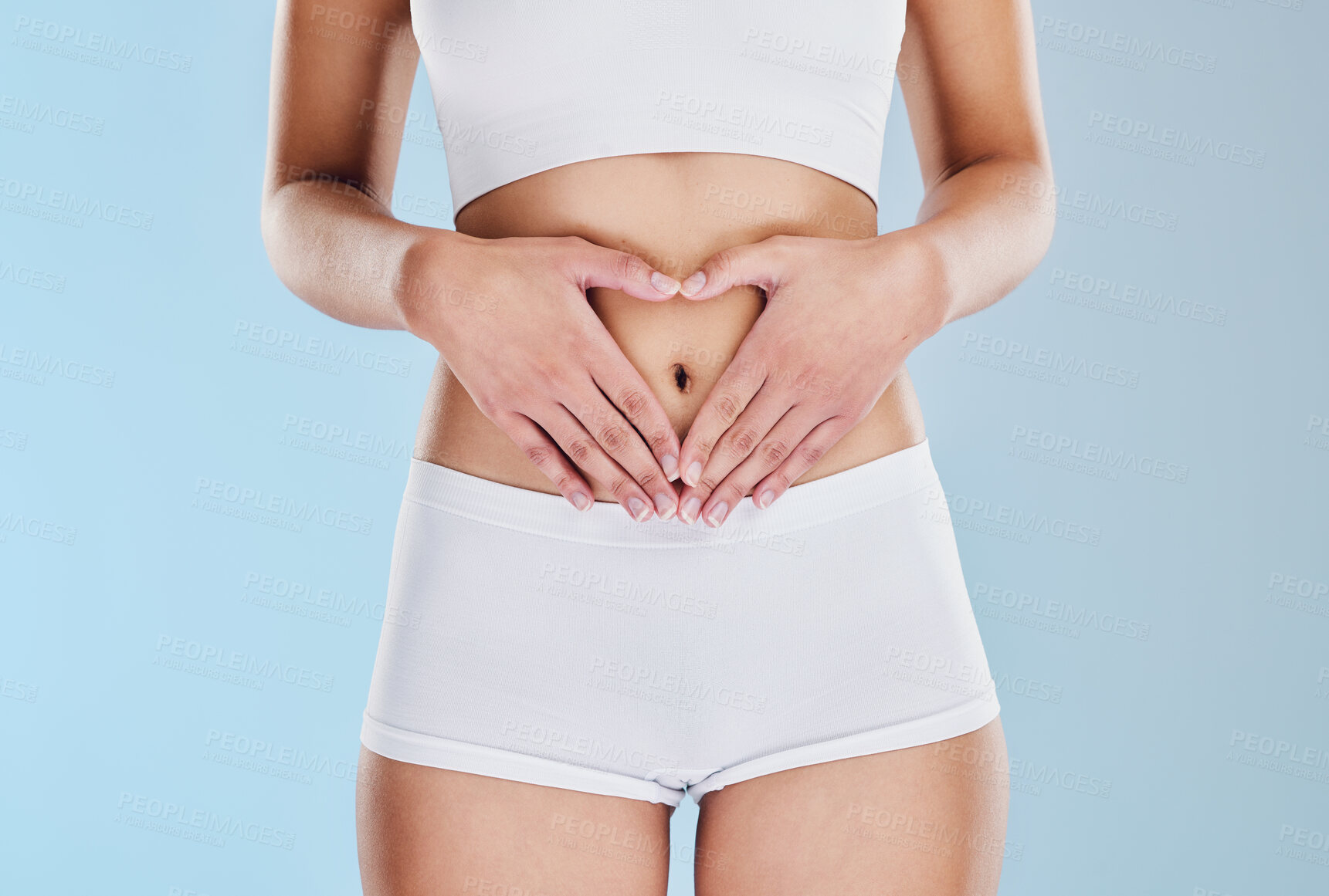 Buy stock photo Healthy stomach, heart and woman hands, wellness and gut health, body contouring and diet on studio blue background. Fitness model belly love, digestion and skincare, laser liposuction and abdomen 