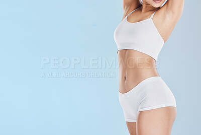 Buy stock photo Fitness, lingerie and body of a woman with health, training and cosmetics against blue mockup studio background. Wellness, beauty and stomach of girl in sports, dermatology and with mock up space