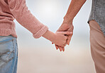 Holding hands to show support, love and care outdoor to show trust and quality time together. Woman, man and couple outdoor with hand hold showing commitment, people solidarity and loving help