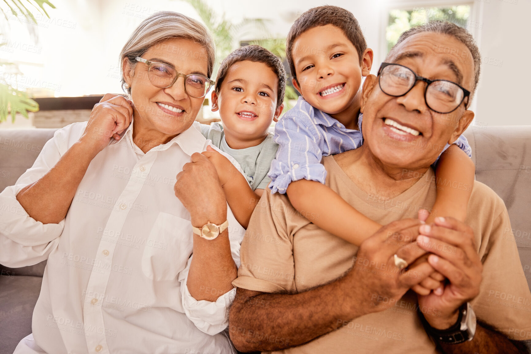 Buy stock photo Love, happy family and kids relax with grandparents on a sofa, hug and bonding in a living room. Portrait, seniors and children embracing, laughing and enjoying visit to grandma and pa on the weekend