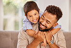 Father, child and family love hug of a parent and kid on a home living room couch. Dad and kid with a happy smile on a lounge sofa at a house in the morning smiling about quality fun time together
