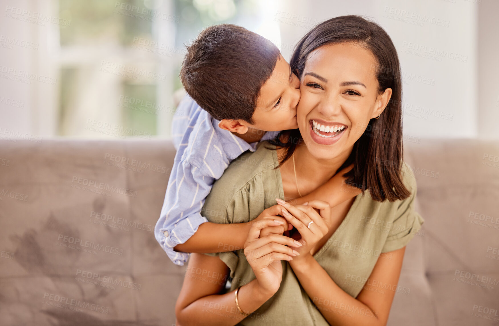 Buy stock photo Kiss, mother and child with hug for love, care and gratitude on mothers day on the sofa of the living room in their house. Portrait of a happy, young and mom with a smile for affection from her kid