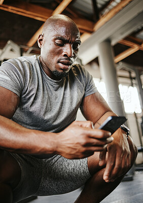 Buy stock photo Phone, fitness and sweat with a black man athlete checking his social media after a workout or exercise at the gym. Training, mobile and health with a male tracking his progress on an internet app