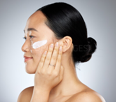 Buy stock photo Beauty, skin and woman with face and cream, skincare and natural cosmetics advertising, facial product and treatment with grey studio background. Asian model, moisturizer and healthy body care.