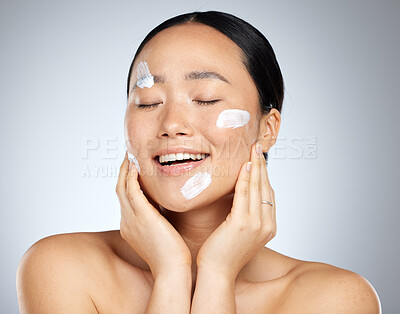 Buy stock photo Beauty, skincare and facial product with woman and cream on face for wellness, spa and clean. Sunscreen, cosmetics and health with asian girl for luxury, salon and model lifestyle in gray background 