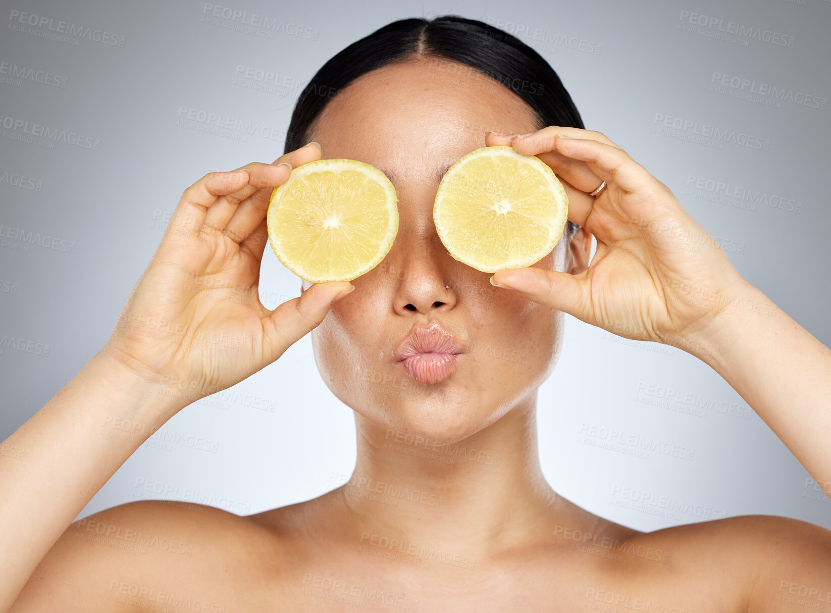 Buy stock photo Woman, eyes and skincare holding fruit for healthy, nutrition or cosmetic treatment against a grey studio background. Hands of female in beauty care for skin facial with sliced lemons for vitamin C