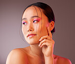 Beauty, makeup and asian woman with colourful eyeshadow isolated against a studio background. Cosmetics, glowing skin and chinese woman with glamour eye makeup. Smooth and perfect skin after a facial