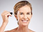Elderly, woman and skincare with serum, cosmetic and beauty against grey, studio or background. Model, smile and skin for makeup, cosmetics and senior with happiness, anti-aging and care for health