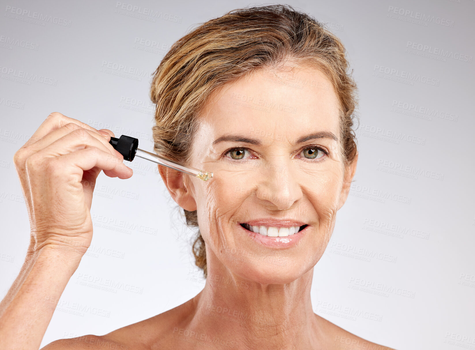 Buy stock photo Elderly, woman and skincare with serum, cosmetic and beauty against grey, studio or background. Model, smile and skin for makeup, cosmetics and senior with happiness, anti-aging and care for health