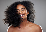 Black woman, hair and beauty, hair care or curly hair on gray studio background. Smile, skincare and young beautiful female model from Nigeria with healthy curls after luxury salon treatment.






