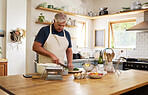Cooking, food and senior man in kitchen with green, raw and fresh vegetables for health, diet and wellness. Wine, salad and meal on table by retired nutritionist relax, prepare and enjoy healthy dish