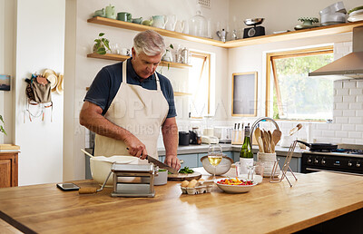 Buy stock photo Cooking, food and senior man in kitchen with green, raw and fresh vegetables for health, diet and wellness. Wine, salad and meal on table by retired nutritionist relax, prepare and enjoy healthy dish