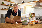 Senior, man and tablet in kitchen, cooking or internet for reading, video or email in house. Elderly, home and food for recipe, digital or ingredients on internet, web or app in home for retirement