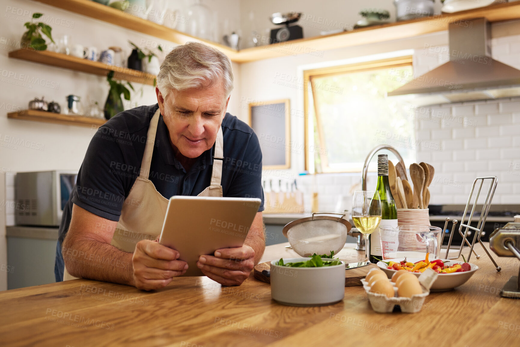Buy stock photo Senior, man and tablet in kitchen, cooking or internet for reading, video or email in house. Elderly, home and food for recipe, digital or ingredients on internet, web or app in home for retirement