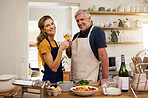Wine, toast and senior couple in a kitchen for cooking, bonding and celebrating their relationship in their home. Happy family, love and food by elderly man and woman relax, drink and prepare a meal