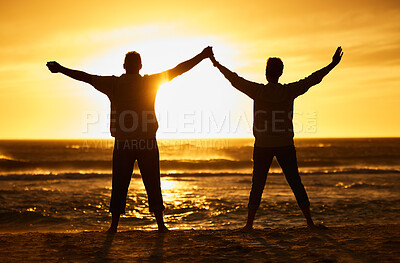 Buy stock photo Beach, sunset and silhouette of a couple with freedom on adventure, journey or travel vacation together. Carefree, nature and people enjoying their outdoor holiday at the ocean or sea in the evening.