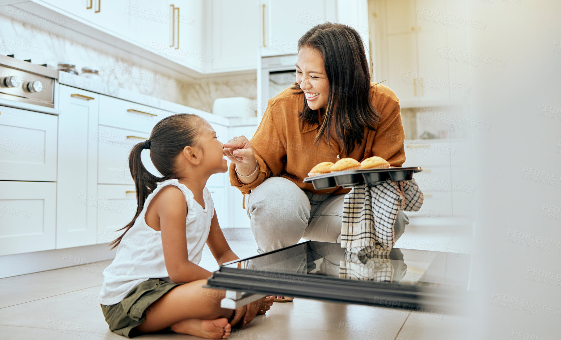 Buy stock photo Cooking, cupcake and happy family of mother and child baking dessert food in oven and enjoy fun quality time together. Love, happiness and youth girl or kid bonding with mom, mama or woman in kitchen
