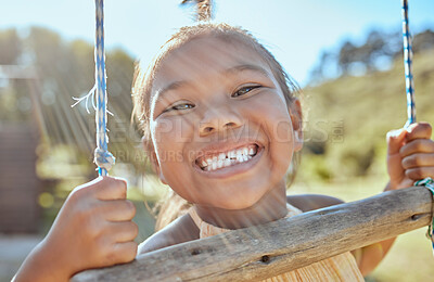 Buy stock photo Smile, teeth and small girl on swing in outdoor park, happiness fun and playing outside in Indonesia. Health, happy face and a portrait of a young child swinging in garden at home in summer holiday.