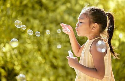 Buy stock photo Bubbles, outdoor and girl in a nature park feeling relax, playful and content by sunshine. Child from Taiwan blow a bubble in the spring sun feeling peace, calm and content with happiness on vacation