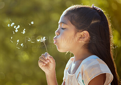 Buy stock photo Spring, freedom and girl blowing dandelion flowers for hope, growth and environment in park. Happy, light and health with child wish on plant in peace and nature garden for summer, wellness and goals