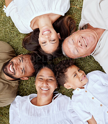 Buy stock photo Big family, face and portrait smile above relaxing in quality bonding time together on the grass in the outdoors. Happy family smiling in joyful happiness lying in relax for summer break in the park
