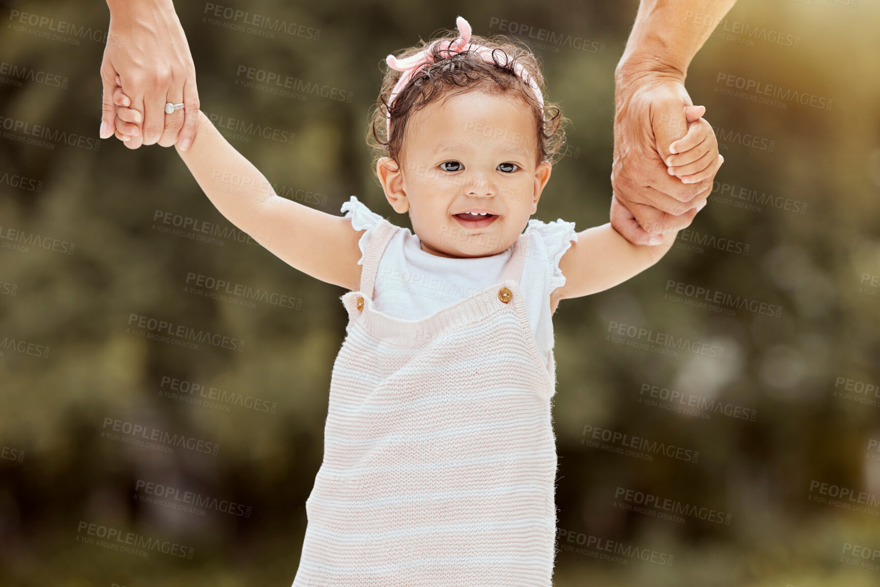 Buy stock photo Baby, walking and learning with holding hands with parents in garden, help and girl. Child, walk and teaching to balance, coordination or motor skills for steps with support, care or love in backyard