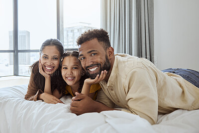 Buy stock photo Family, hug and smile, parents and child lying on bed in portrait, love and care together, home and bonding. Mother, father and girl kid happy, bedroom and spending quality time in family home.