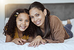 Mother, girl and happy family home morning on a bedroom bed feeling family love and care. Portrait of a mama and child in a house bonding together with a smile lying with happiness smiling content