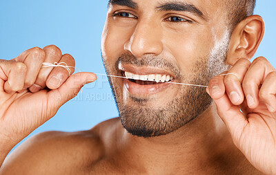 Wellness, dental and floss man cleaning teeth for good oral hygiene, health and tooth care. Clean, healthy and confident smile for flossing product advertising in blue studio closeup.