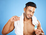Man, dental floss and smile in care for teeth, health or clean hygiene against a blue studio background. Happy male smiling for fresh mouth, grooming or flossing in oral, gum or dental treatment