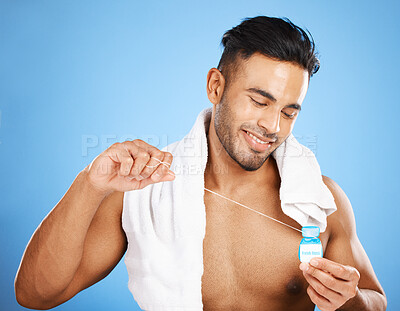 Buy stock photo Man, dental floss and smile in care for teeth, health or clean hygiene against a blue studio background. Happy male smiling for fresh mouth, grooming or flossing in oral, gum or dental treatment