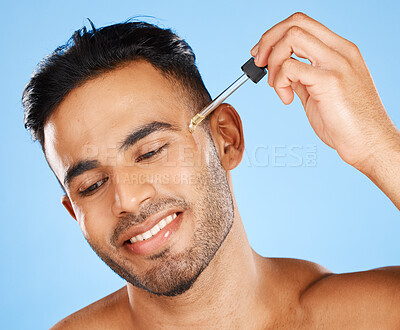 Buy stock photo Beard oil, skincare serum and young man face makeup, hair growth product and wellness on blue background. Happy arab guy model drop essential oil, hyaluronic acid and body cosmetics for dermatology