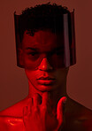 Red future night, black man portrait and futuristic punk glasses on face against dark background in studio. Cyber model man, plastic visor mask and cyberpunk aesthetic with creative wall backdrop