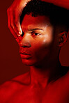 Red beauty, light and face of model with creative shadow design, artistic neon lighting and luxury skincare. Sweat, hard work and aesthetic creativity of serious black man isolated on red background 