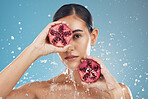 Beauty, health and skincare of woman with pomegranate, water splash and blue studio background. Wellness, healthy lifestyle or female model from Canada with fruit for vitamin c, nutrition or minerals
