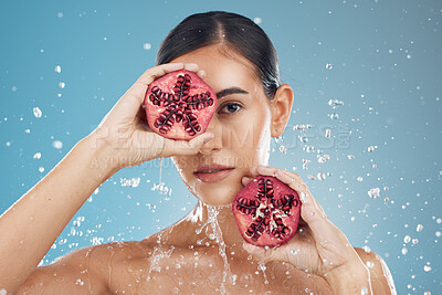 Buy stock photo Beauty, health and skincare of woman with pomegranate, water splash and blue studio background. Wellness, healthy lifestyle or female model from Canada with fruit for vitamin c, nutrition or minerals
