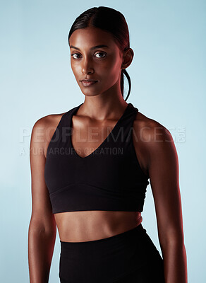 Buy stock photo Fitness, health and sports portrait of woman isolated on a blue studio background. Vision, motivation and athletic female from India with goals for wellness, exercise or serious training workout.