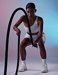 Girl, fitness and rope training exercise for cardio, muscle and endurance practice with color studio background. Focus, health and power of Indian woman training with gym wellness workout gear.


