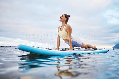 Ocean, surfing and woman doing yoga on surfboard in morning, ready to surf and relax. Wellness, water sports and girl doing stretching exercise on paddle in sea, enjoy calm, waves and peace in nature