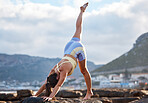 Yoga, woman and leg stretching in city nature outdoors for mental health and body wellness. Young healthy zen fitness person, calm meditation stretch and pilates lifestyle motivation on beach rocks