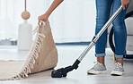 Vacuum, floor and woman cleaning under a carpet in the living room of a house. Housekeeping, service and cleaner vacuuming in the lounge with a rug or mat for care and disinfection of dirt in home