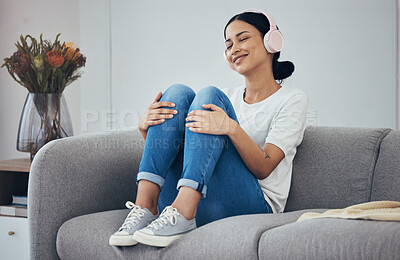 Buy stock photo Relax, headphones and woman on sofa in home living room streaming music, podcast or radio. Happy, smile and carefree female from Canada enjoying listening to audio, playlist or favorite song in house