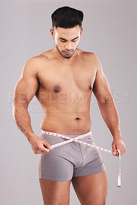 Buy stock photo Weightloss, fitness and man with measure tape standing in a studio with a gray background. Health, strong and athlete with a healthy, exercise and diet lifestyle measuring his weight after a workout.