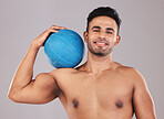 Health, fitness and medicine ball with a man athlete in studio on a gray background for exercise or training. Gym, wellness and workout with an athletic or strong male posing with sports equipment